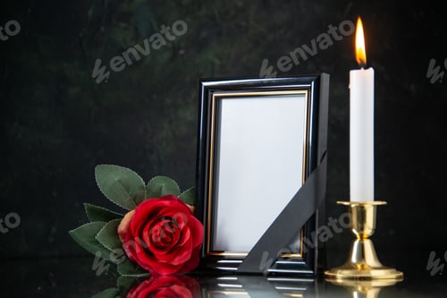 Preview: front view of burning candle with red flower on black background evil death war