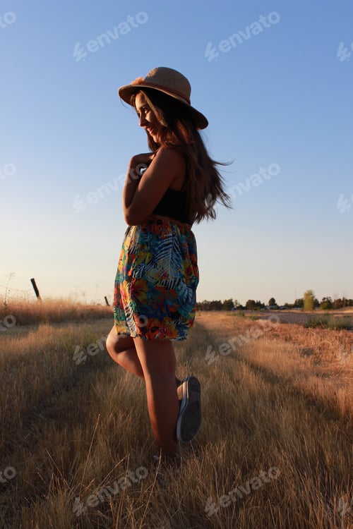 Preview: Young Woman Posing in a Field at Sunset