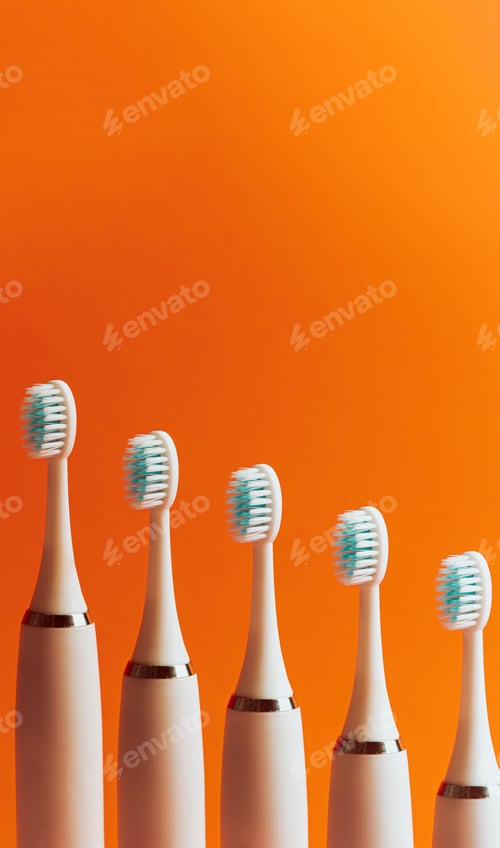 Preview: Conceptual shot of electrical toothbrush over a pink pastel background with copy space