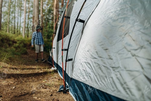 Preview: cute caucasian boy putting up a tent. Family camping concept