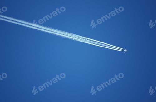 Preview: Low angle shot of an airplane flying in a clear blue sky in Austria.