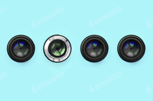 Preview: A few camera lenses with a closed aperture lie on texture background of fashion pastel blue