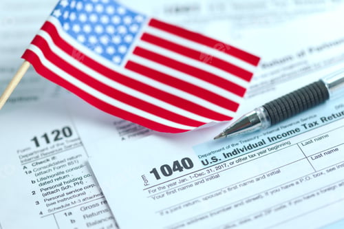 Preview: Understanding tax forms with an American flag and pen on a table in a home office