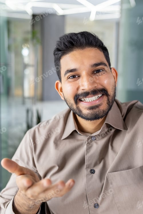 Preview: Friendly man gesturing while on a video call indoors