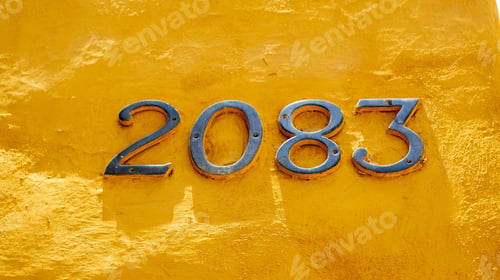 Preview: Close-up shot of a metallic number 2083 on amber yellow wall background.