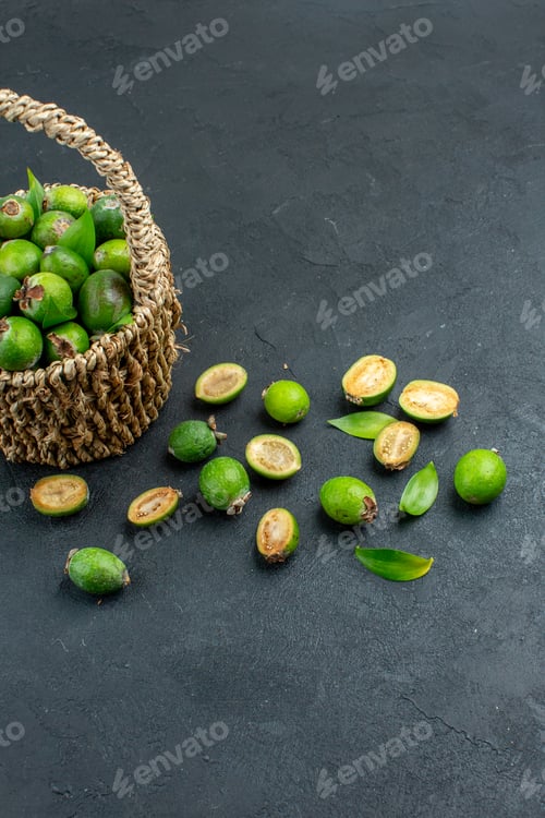 Preview: front view fresh feijoas in basket on dark background with copy space