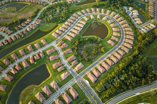 Preview: View from above of densely built residential houses near retention ponds