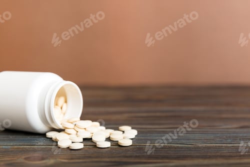 Preview: Medicine bottle and white pills spilled on a light background. Medicines