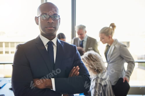Vista previa: Confident young businessman with colleagues at work in the background