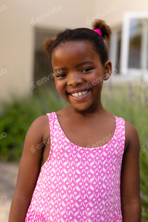 Preview: Portrait of smiling cute african american girl wearing pink sleeveless top
