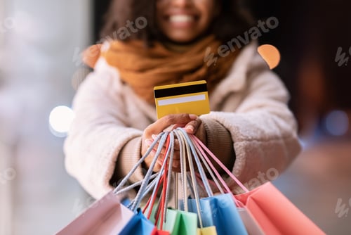 Preview: Unrecognizable black woman showing credit card and shopping bags
