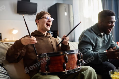 Preview: Friends Cheering with Drum Watching Match Or Competition Sitting on Sofa