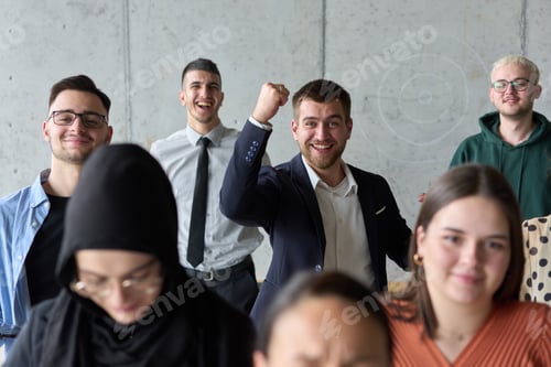 Preview: A diverse team of business professionals ecstatically celebrating their success in a modern office
