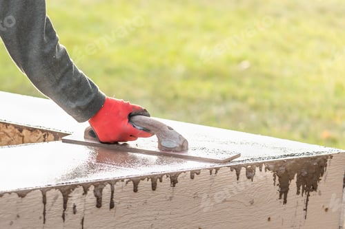 Preview: Construction Worker Using Wood Trowel On Wet Cement Forming Coping Around New Pool