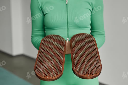 Preview: Close Up of Young Woman Holding Nail Board to Camera in Yoga Studio