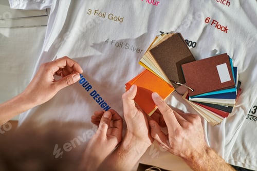 Preview: Top view of young craftsman pointing at color swatches while working with african american