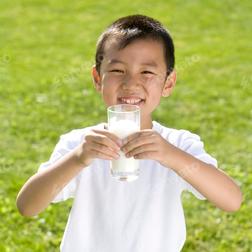 Preview: Young boy holding a glass of milk