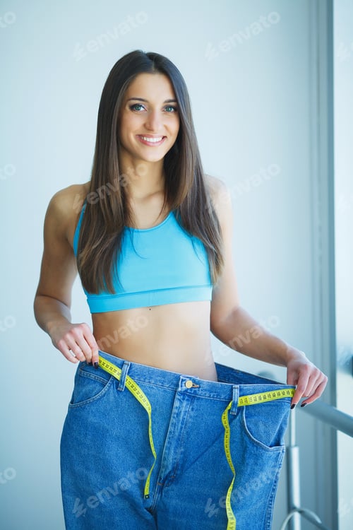 Preview: Diet. Dieting concept. Woman in Sportswear Measuring Her Waist
