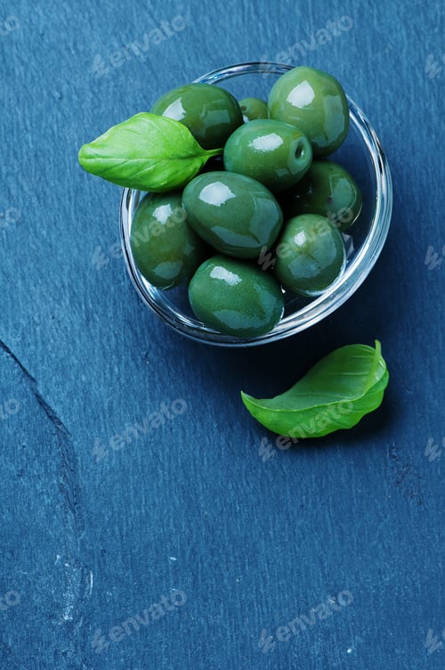 Preview: Green olives on the black table