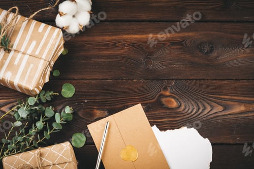 Preview: Empty letter with a feather on old wooden background decorated with christmas objects