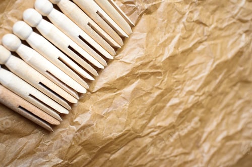 Preview: Old American style wooden clothespins for holding clothes, on a paper background.