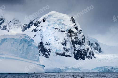Preview: Landscape of icebergs in the ocean under a cloudy sky in Antarctica