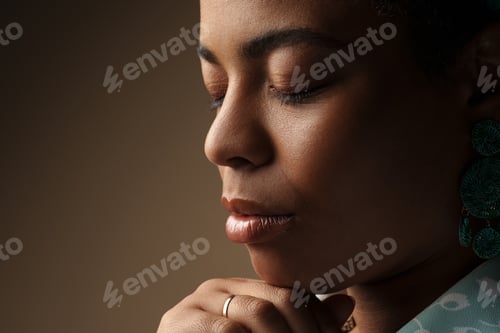Preview: Young black woman wearing earring posing with her eyes closed