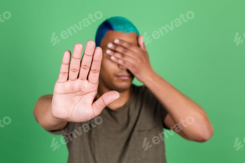 Preview: African man in casual on green background cover his eyes with hands showing stop gesture