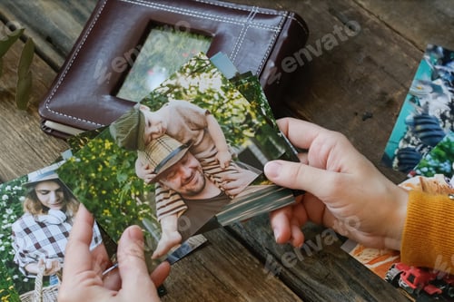 Preview: Photo printing, family memories. Woman looks at printed photos for family picture album.