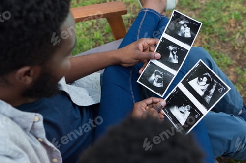Preview: Couple looking at sonography in park
