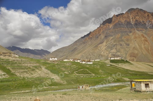 Preview: View of a village next to a beautiful rocky mountain with flowing a river