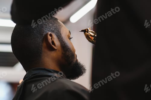 Preview: Closeup of process of trimming of hair in barber shop. Qualified barber keeping clipper