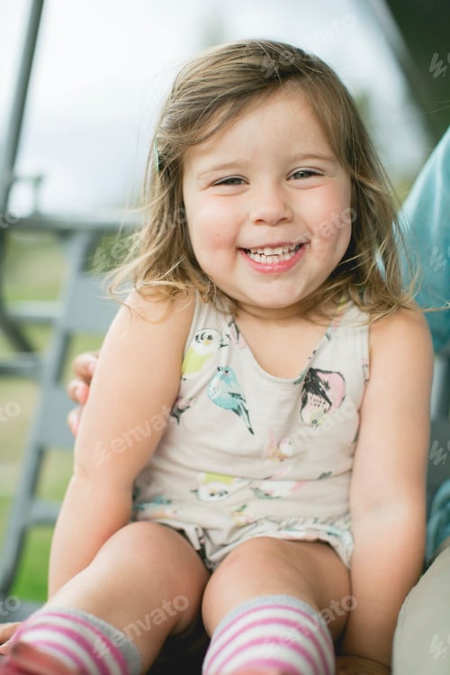 Preview: Portrait of happy girl looking at camera smiling
