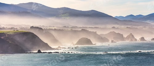 Preview: Beautiful shot of a bright blue sea on a sunny day near a rocky shore in Asturias, Spain