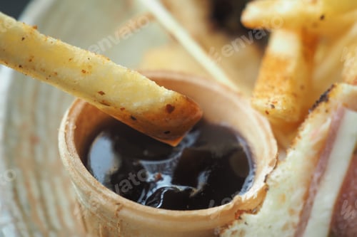 Preview: Savory fries dipped in rich sauce at a cozy restaurant