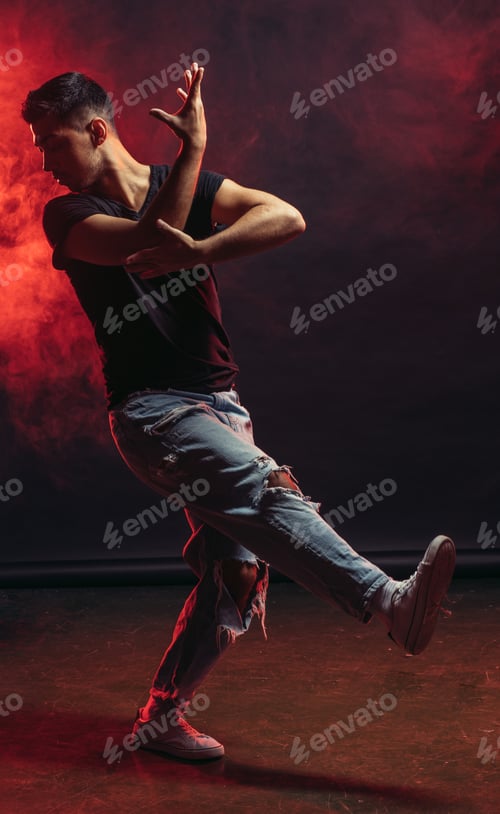 Preview: Single young man dancer wearing jeans showing various steps isolated in smoky studio