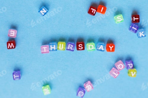 Preview: inscription thursday made by multicolor plastic cubes on a blue background.