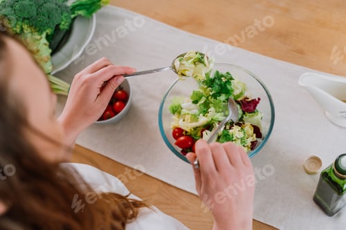 Preview: woman preparing a salad in the kitchen