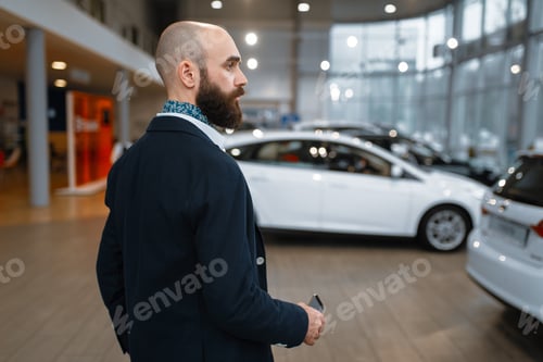 Preview: Smiling man poses in car dealership
