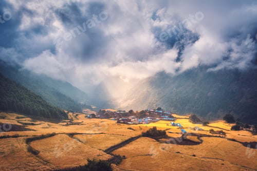 Preview: Village on the hill lighted by a sunbeam at sunset
