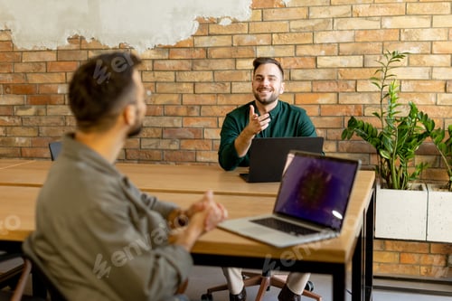 Preview: Collaboration in Motion, Professionals Working Together in a Modern Brick-Walled Office