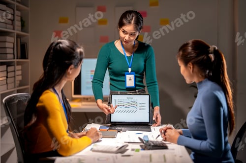 Preview: Three women are sitting at a table with a laptop open in front of them