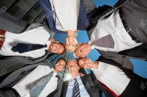 Preview: Portrait of happy business team huddling outside office building