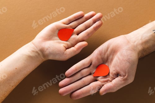 Preview: Hands of caucasian woman and man holding blood drops, on brown background