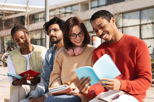 Preview: Smiling millennial different modern students read books, study together at university campus