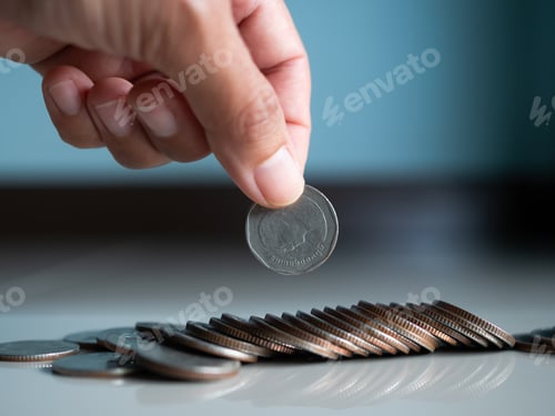 Preview: Stack coin.closeup finger woman holding money with blur pile cash on blue background