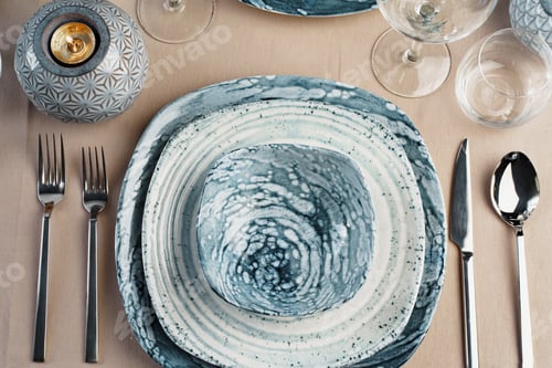 Preview: Details of a stylish table setting with textured ceramic dishes