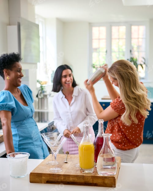 Preview: Three Mature Female Friends At Home Having Fun Mixing Cocktails Together