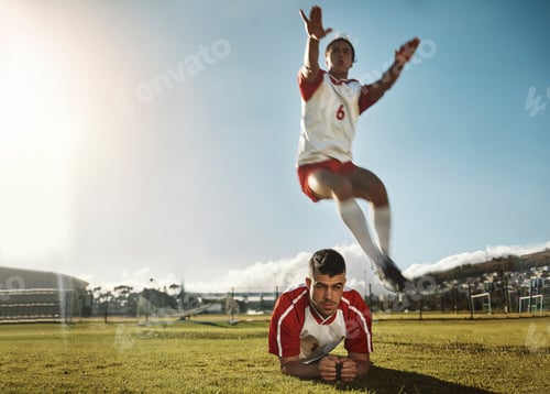 Preview: Soccer, fitness and training with a sports man jumping over his teammate during practice on a grass
