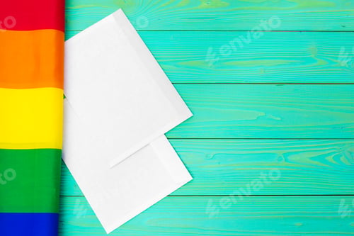 Preview: Bright rainbow gay flag on wooden background and blank space